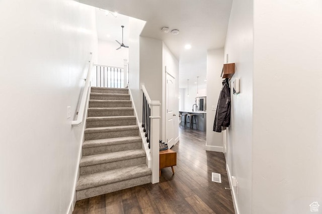 staircase featuring baseboards, visible vents, wood finished floors, and recessed lighting