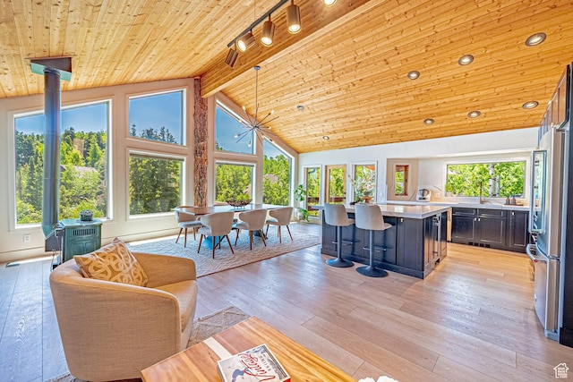 4414 Hidden Cove Rd, Park City, UT 84098 - living area with a wood stove, wooden ceiling with exposed beams, light wood-style flooring, and high vaulted ceiling