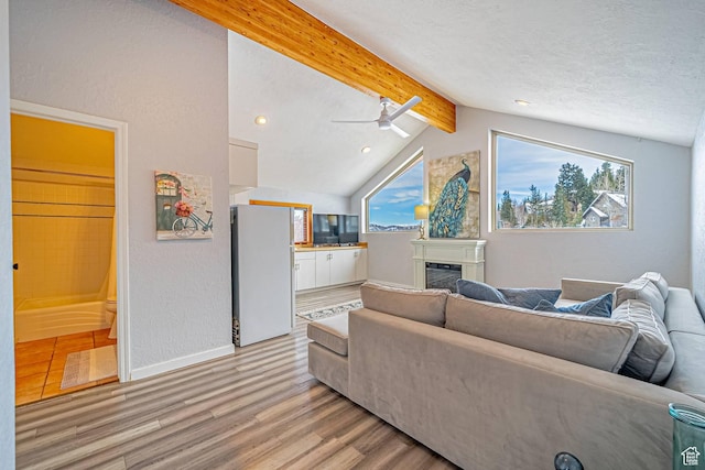 4414 Hidden Cove Rd, Park City, UT 84098 - living room with baseboards, a glass covered fireplace, lofted ceiling with beams, a textured ceiling, and light wood-style floors