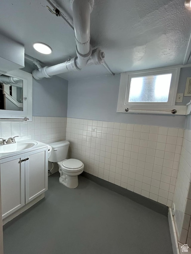 330 E 300 N, Price, UT 84501 - bathroom with concrete floors, toilet, tile walls, a textured ceiling, and vanity