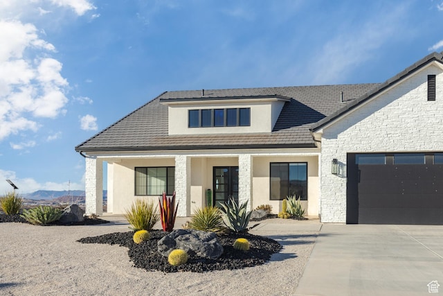 3311 E Barrel Roll Dr, St George, UT 84790 - view of front of home featuring a garage, concrete driveway, stone siding, and stucco siding