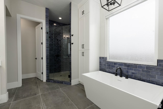 3311 E Barrel Roll Dr, St George, UT 84790 - bathroom with a healthy amount of sunlight, a soaking tub, a shower stall, and tile patterned floors