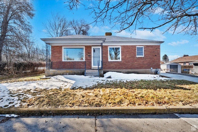 bungalow featuring brick siding and a chimney