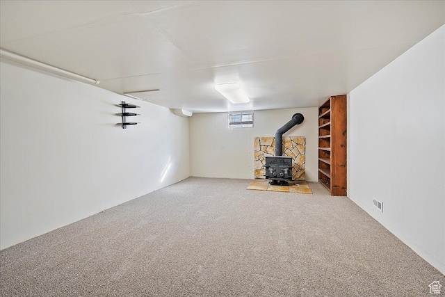 867 33rd St, Ogden, UT 84403 - below grade area with a wood stove, carpet flooring, and visible vents