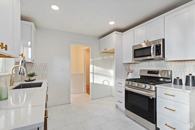 kitchen featuring white cabinets, appliances with stainless steel finishes, marble finish floor, a sink, and recessed lighting