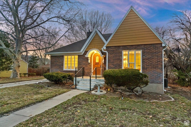 view of front of property with a front lawn and brick siding