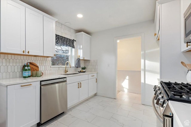 kitchen with white cabinets, marble finish floor, stainless steel appliances, and a sink