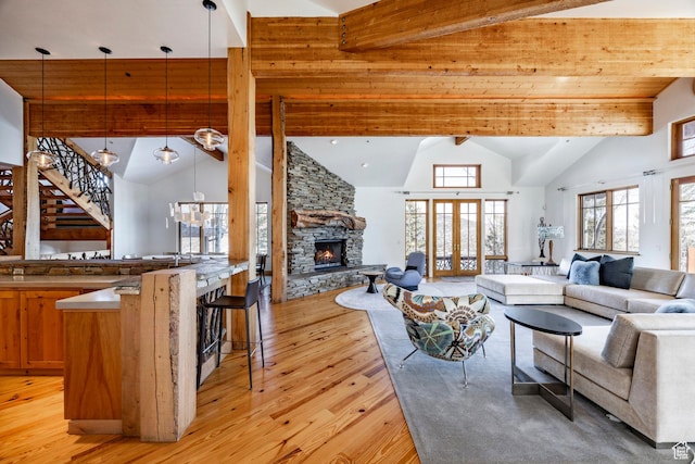 2667 Aspen Springs Dr, Park City, UT 84060 - living area featuring high vaulted ceiling, light wood-style flooring, beam ceiling, a stone fireplace, and stairs