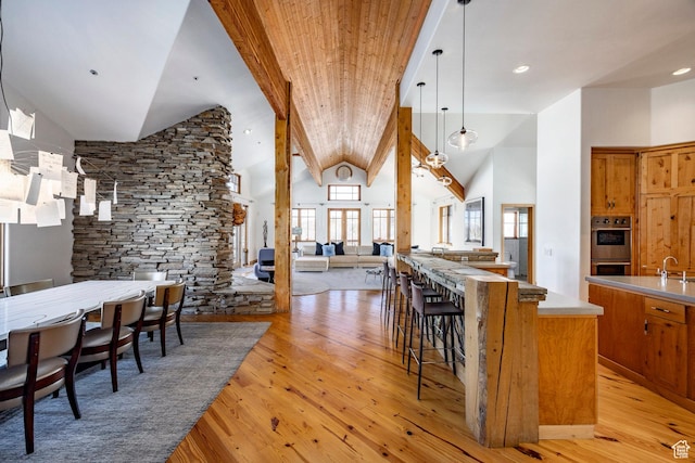 2667 Aspen Springs Dr, Park City, UT 84060 - kitchen with double oven, light wood-style floors, brown cabinetry, open floor plan, and decorative light fixtures