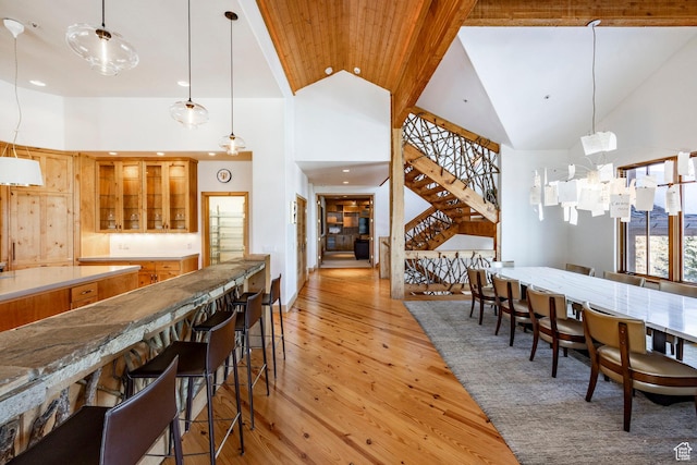 2667 Aspen Springs Dr, Park City, UT 84060 - dining area with high vaulted ceiling, bar, stairs, light wood finished floors, and recessed lighting