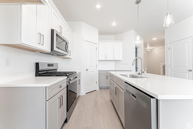 712 W 4500 S Unit 304, Mapleton, UT 84664 - kitchen with appliances with stainless steel finishes, a sink, light wood finished floors, light countertops, and an island with sink