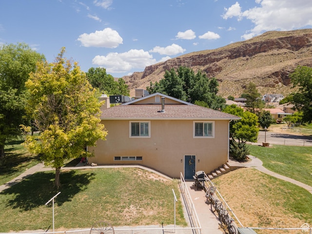 1502 S 325 W, Hurricane, UT 84737 - view of property exterior featuring roof with shingles, a mountain view, a lawn, and stucco siding