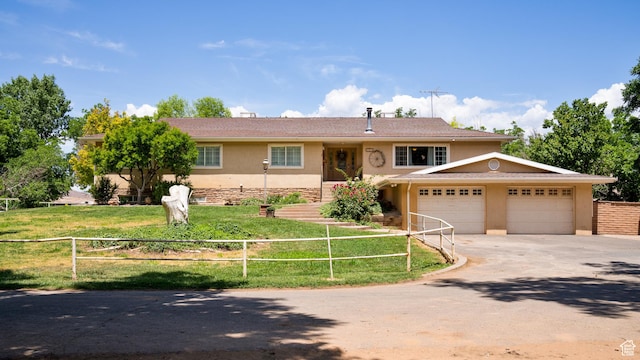 view of front of house with a garage, concrete driveway, stucco siding, fence, and a front yard