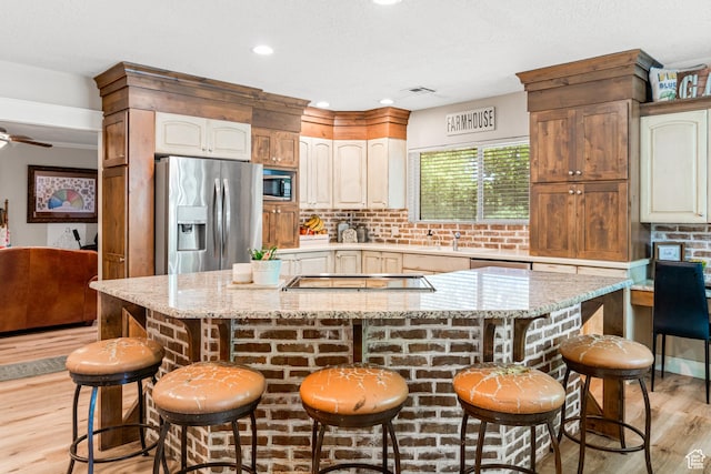1502 S 325 W, Hurricane, UT 84737 - kitchen with appliances with stainless steel finishes, a center island, a kitchen bar, and light stone countertops