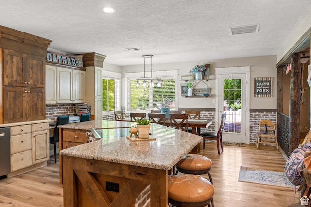 1502 S 325 W, Hurricane, UT 84737 - kitchen with light wood-type flooring, decorative light fixtures, a kitchen island, and visible vents