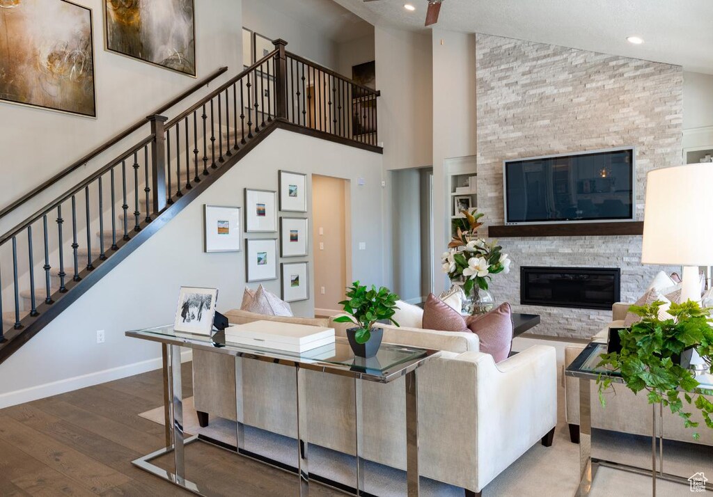 6343 W Teton Ranch Dr Unit 315, Herriman, UT 84096 - living room with baseboards, a glass covered fireplace, a towering ceiling, stairway, and dark wood-style flooring