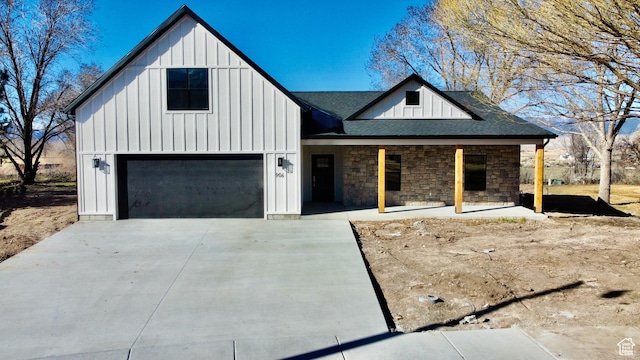 modern farmhouse featuring board and batten siding, roof with shingles, and driveway