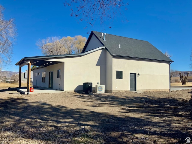 back of house featuring a patio area, cooling unit, and stucco siding