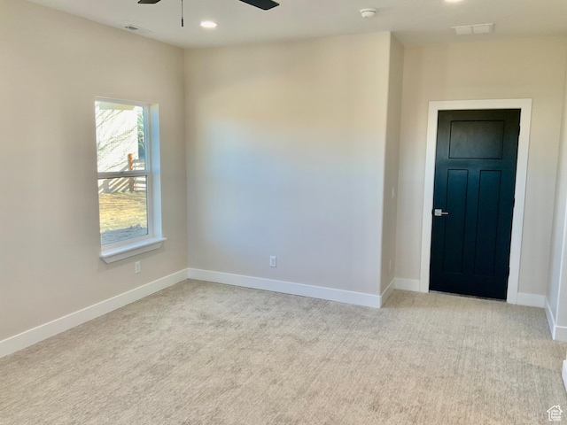 unfurnished room with ceiling fan, recessed lighting, light colored carpet, visible vents, and baseboards