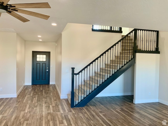 entryway with stairway, baseboards, wood finished floors, and recessed lighting