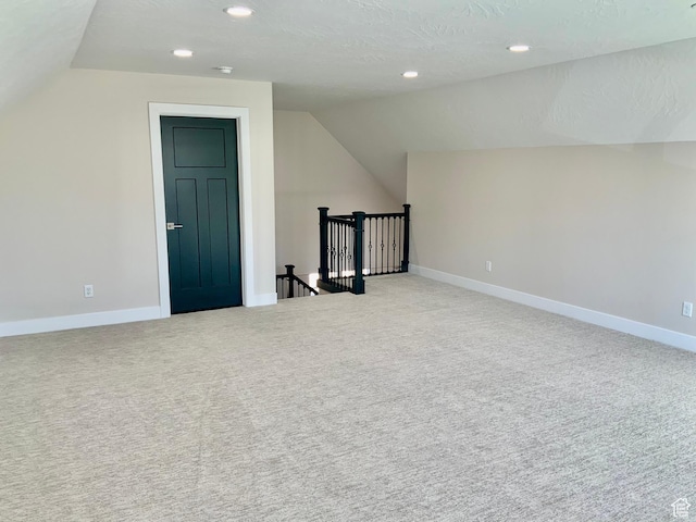 additional living space featuring recessed lighting, light carpet, vaulted ceiling, and baseboards