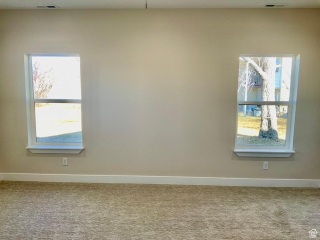 carpeted empty room with baseboards and visible vents