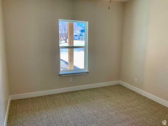 empty room featuring a healthy amount of sunlight, carpet flooring, and baseboards