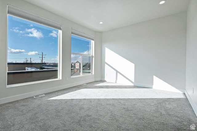 spare room featuring light carpet, baseboards, visible vents, and recessed lighting