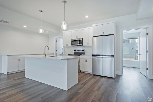 kitchen with light countertops, hanging light fixtures, appliances with stainless steel finishes, white cabinetry, and a sink