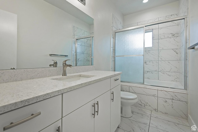 bathroom featuring marble finish floor, toilet, tiled shower / bath, and vanity