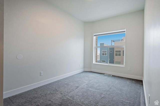 unfurnished room featuring carpet flooring, visible vents, and baseboards