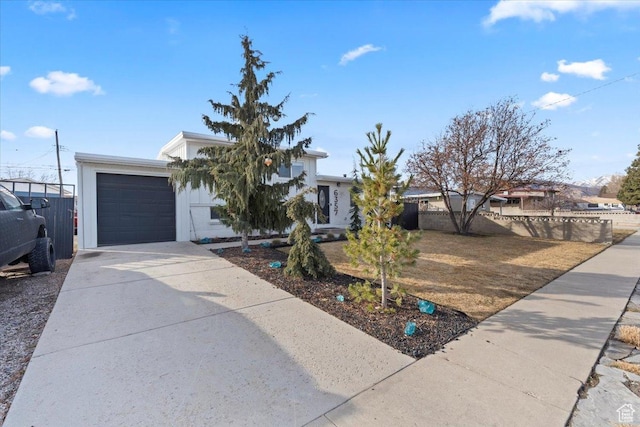 6357 W 3570 S, West Valley City, UT 84128 - view of front facade with concrete driveway, an attached garage, and fence