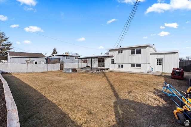 6357 W 3570 S, West Valley City, UT 84128 - rear view of house with board and batten siding, a patio area, fence, and a lawn