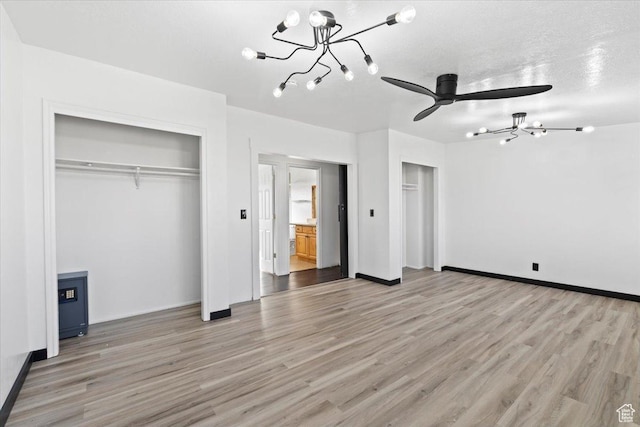 6357 W 3570 S, West Valley City, UT 84128 - unfurnished bedroom featuring light wood-type flooring, a notable chandelier, and two closets