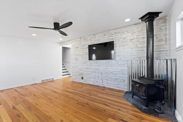 6357 W 3570 S, West Valley City, UT 84128 - living room with wood finished floors, visible vents, a ceiling fan, stairway, and a wood stove