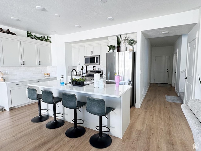 187 W 470 N, Smithfield, UT 84335 - kitchen featuring stainless steel appliances, light wood-style floors, and a kitchen breakfast bar