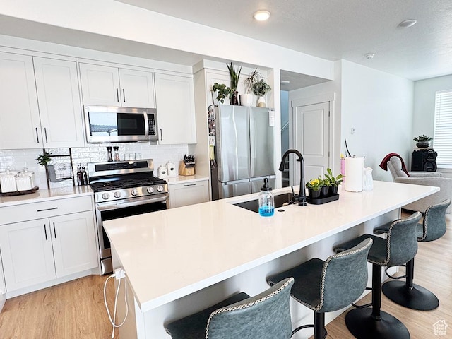 187 W 470 N, Smithfield, UT 84335 - kitchen with stainless steel appliances, a breakfast bar, a sink, and light wood-style floors
