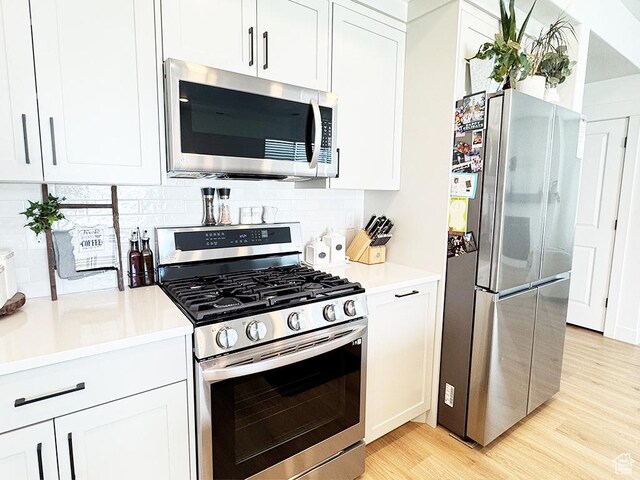 187 W 470 N, Smithfield, UT 84335 - kitchen featuring appliances with stainless steel finishes, light wood-type flooring, white cabinets, and tasteful backsplash