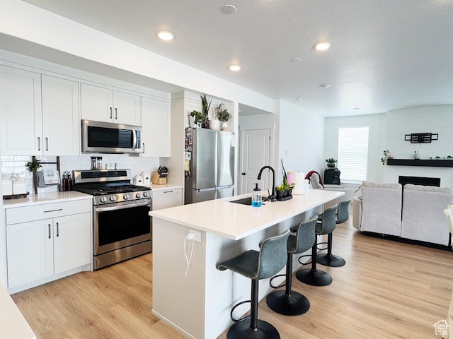 187 W 470 N, Smithfield, UT 84335 - kitchen featuring stainless steel appliances, a sink, light wood-style flooring, and a breakfast bar area