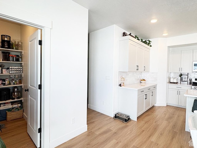 187 W 470 N, Smithfield, UT 84335 - kitchen featuring light wood-style floors, light countertops, and white cabinetry