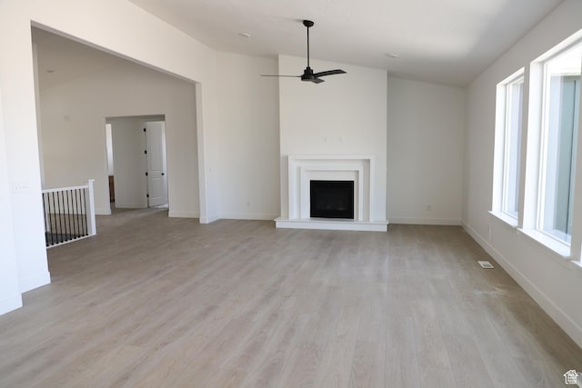 2794 E Liam Ln Unit 101, Eagle Mountain, UT 84005 - unfurnished living room featuring ceiling fan, light wood-style floors, and a fireplace with raised hearth