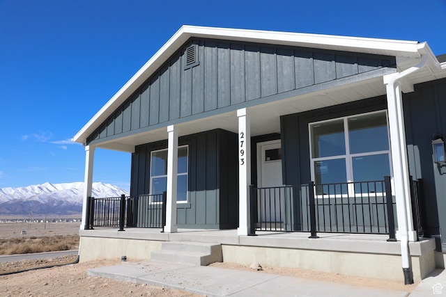 property entrance with board and batten siding, covered porch, and a mountain view