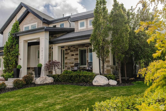 14102 S Sleepy Oaks Ln, Herriman, UT 84096 - view of front of house with stone siding, a front lawn, and a porch
