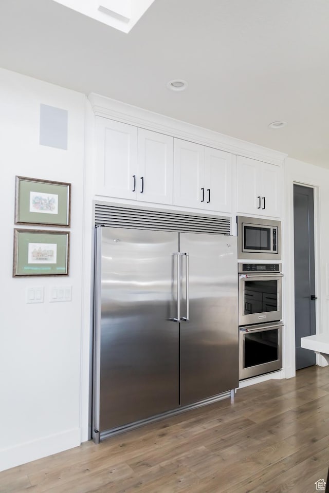 14102 S Sleepy Oaks Ln, Herriman, UT 84096 - kitchen with built in appliances, white cabinetry, wood finished floors, recessed lighting, and baseboards