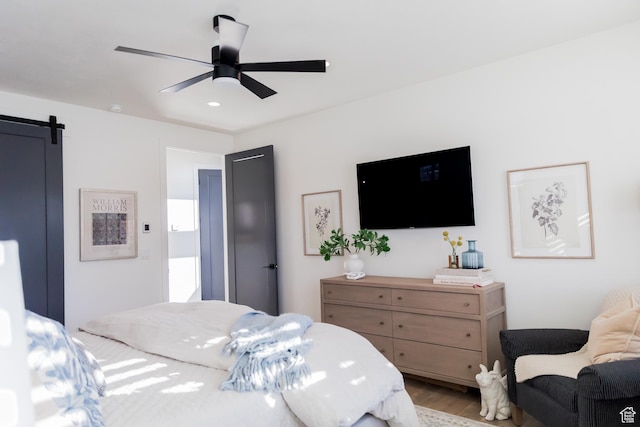 14102 S Sleepy Oaks Ln, Herriman, UT 84096 - bedroom with light wood-type flooring, a barn door, ceiling fan, and recessed lighting