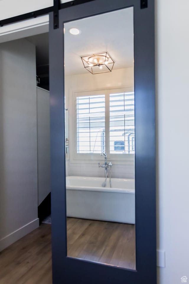 14102 S Sleepy Oaks Ln, Herriman, UT 84096 - bathroom featuring wood finished floors, a freestanding bath, and baseboards