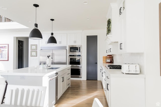 14102 S Sleepy Oaks Ln, Herriman, UT 84096 - kitchen featuring built in appliances, light countertops, light wood finished floors, a kitchen island with sink, and tasteful backsplash