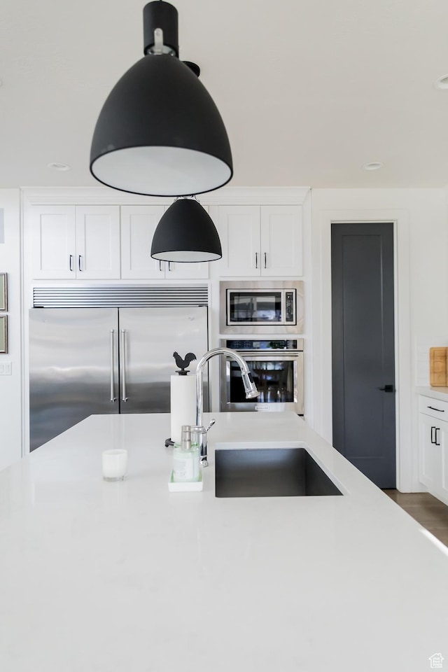 14102 S Sleepy Oaks Ln, Herriman, UT 84096 - kitchen with built in appliances, light countertops, white cabinetry, and a sink