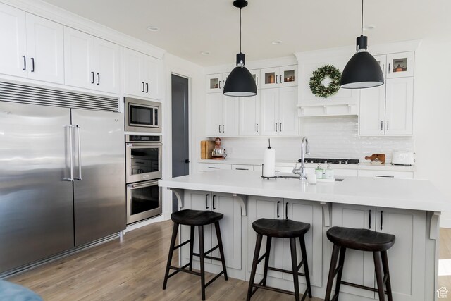 14102 S Sleepy Oaks Ln, Herriman, UT 84096 - kitchen with built in appliances, backsplash, light countertops, and decorative light fixtures