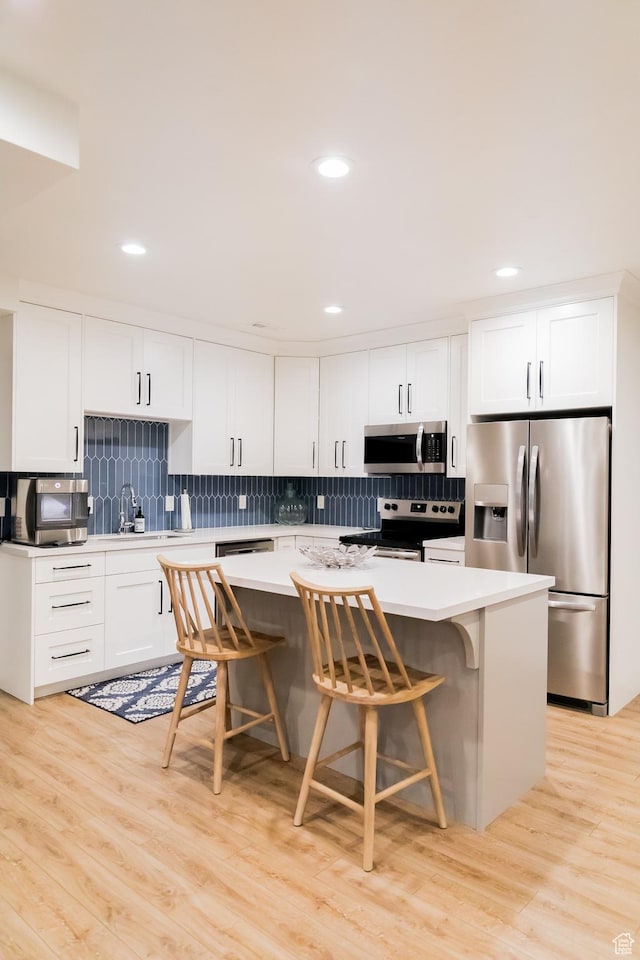 14102 S Sleepy Oaks Ln, Herriman, UT 84096 - kitchen featuring appliances with stainless steel finishes, a center island, backsplash, light countertops, and recessed lighting